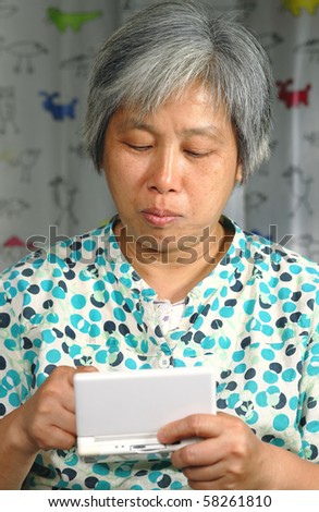 chinese woman playing handheld game console