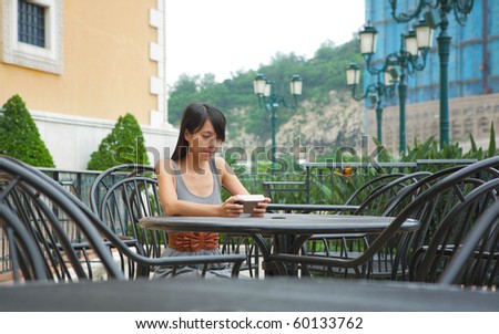 girl watching videos on portable devices in cafe