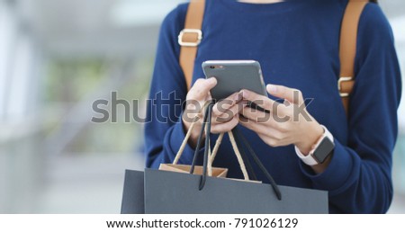 Woman traveler use of mobile phone and hold shopping bag