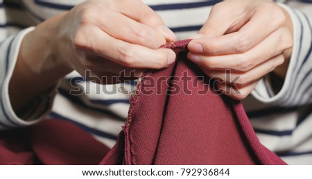 Woman Sews with a needle and thread