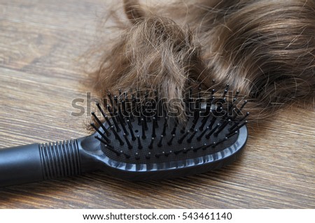 Hair with comb on a wooden table.The concept of hair loss.