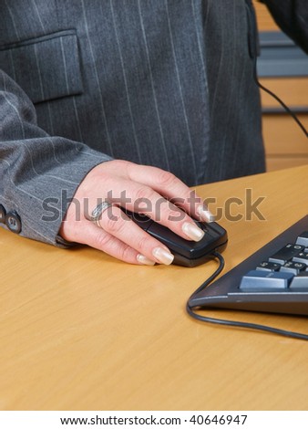 Woman in a suit with a Hand holding computer mouse close up