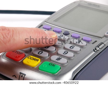 Finger pressing the keypad on a payment terminal. Close up on white background