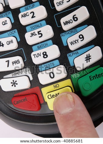 Payment terminal with a finger pushing a button. Close up