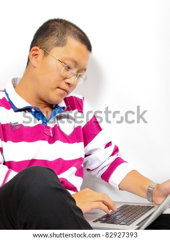 Young chinese man sitting with a laptop