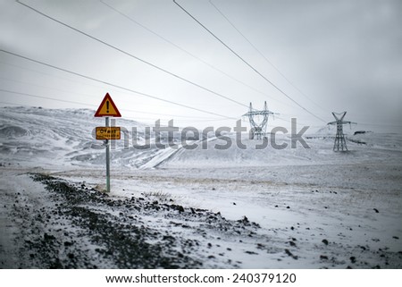 Road signs near an icy road in a winter landscape in Iceland