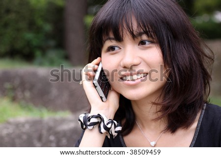stock photo Young Japanese girl worried while talking on the phone
