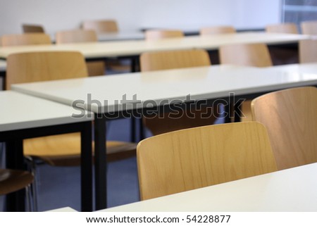 Empty seats in a university classroom with wooden chairs