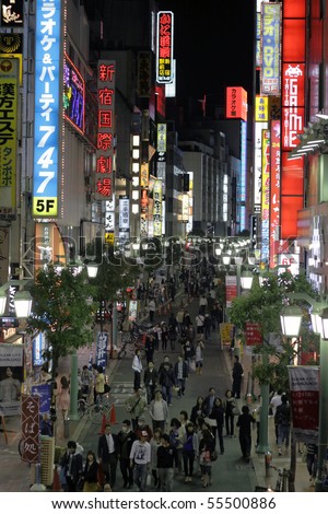 TOKYO - JUNE 13: People walk through light up streets with neon signs on June 13, 2010 in Tokyo.
