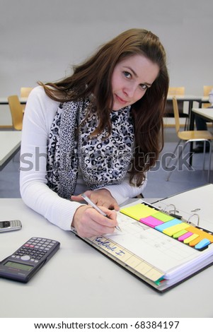 Attractive young Brunette in English class taking notes