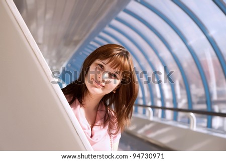 girl peeks out from behind the pillar of the bridge