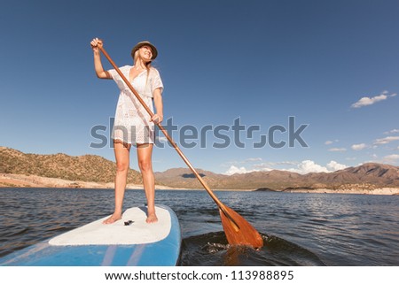 Action Shot of Young Woman on Stand Up Paddle