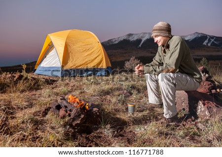 Young Man Camping and Enjoying the Fire