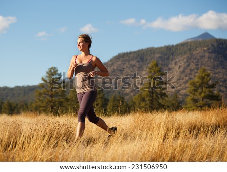 Young Woman Running on Grassy Rural Trail (Runner Leaving Frame/Emphasis on Runner)