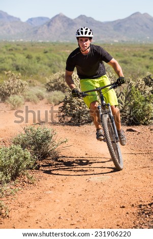 Action Shot of Young Man Biking on Desert Trail