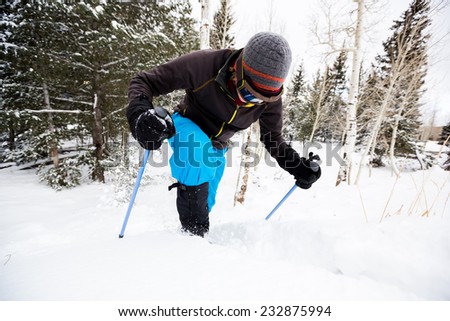 Young Man on Snowshoes Struggles to Get Up Snowbank