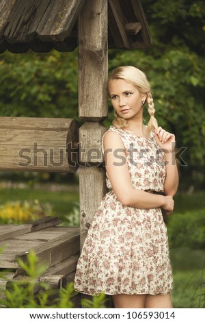 Blonde woman staying near well in village