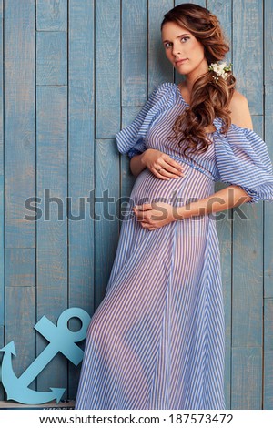 portrait of pregnant woman, ukrainian style, blue dress, sea style