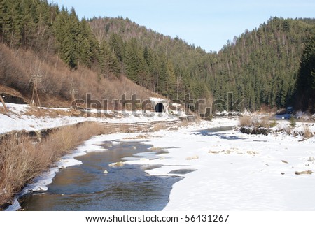 Winter landscape, frozen river, railway tunnel
