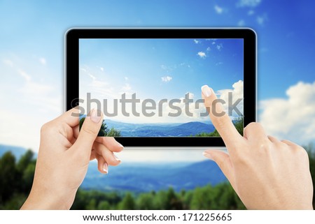 tablet computer in hand on the forest backgrounds