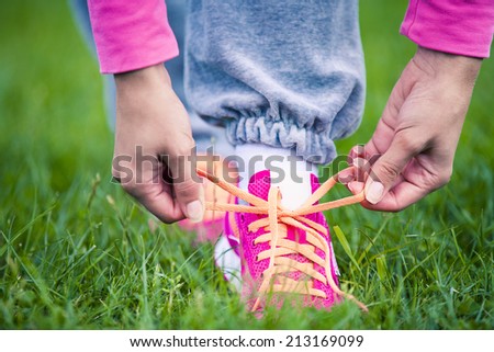 A young woman laces up laces