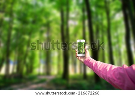 phone in hand on the forest backgrounds
