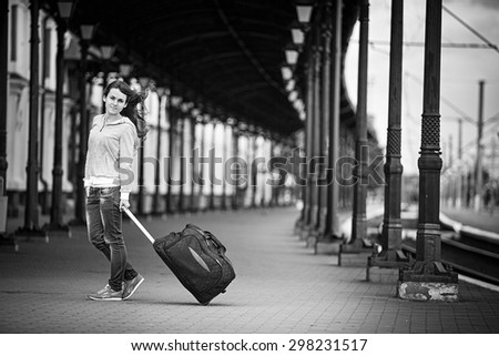a girl on train station waits a train