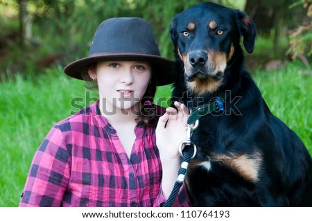 Farm girl with her working cattle dog on a farm in
