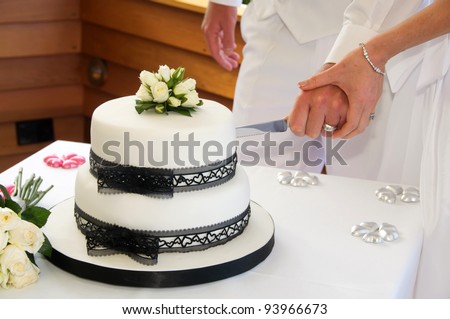 stock photo Wedding cake with black lace ribbon and white icing and little