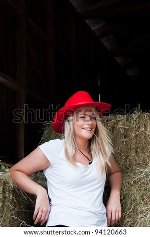 Girl in Hay Barn with red stetson style hat on