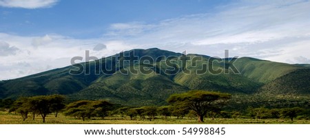 A green mountain rising over the african savanna