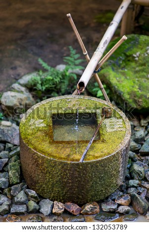 Water drips out of a delicately balanced ancient stone fountain at Ryoanji in Kyoto, Japan