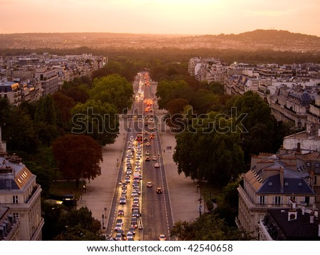 Softly backlit trees frame a Parisian Boulevard at Sunset