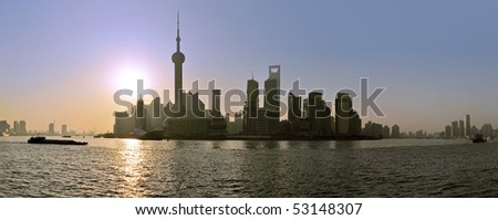 The sun rises behind the skyline of Shanghai\'s Pudong district