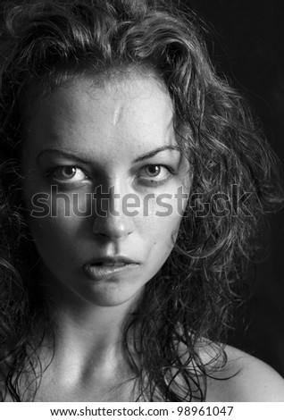 black and white portrait of a girl a woman bite one\'s lips and curly hair
