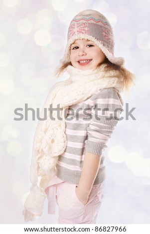 Portrait of happy smiling little girl in hat and scarf