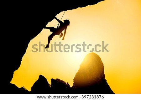Silhouette of man climbing at sunset. Extreme sport concept