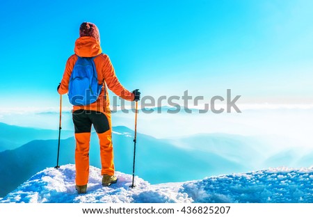 Woman hiker successful on mountain peak summit in winter mountains. Active sport concept.