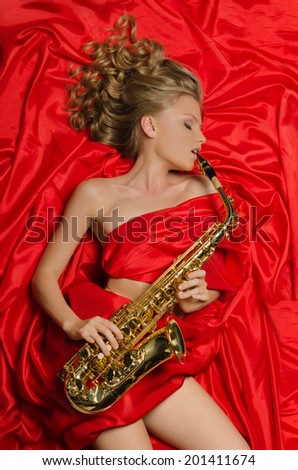 Woman in red enjoys playing the saxophone