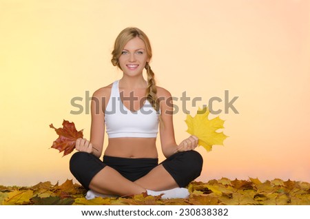 beautiful smiling woman sitting practices yoga in fall