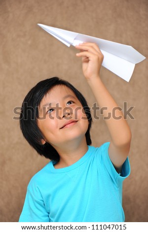 Cute Asian boy playing with paper plane
