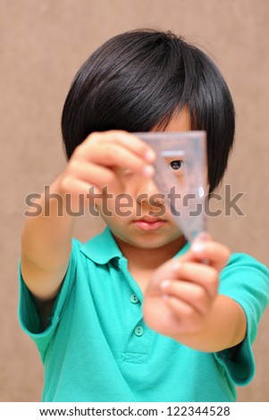 Asian schoolboy holding a set square (triangle)