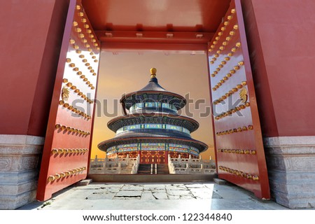 Red Chinese gate opening to a Chinese building in sunset light ( Temple of Heaven or Tiantan Temple in Beijing - China )
