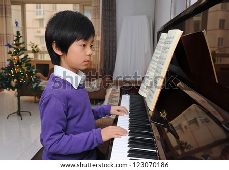 Young Asian boy learning piano