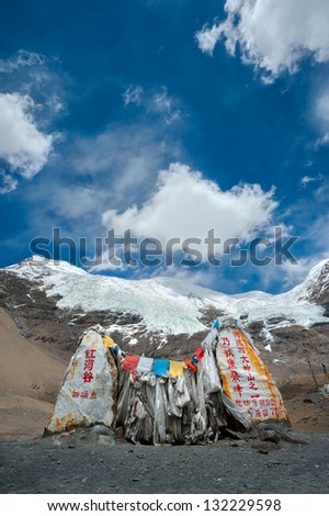 Stone landmark at mountain pass beneath holy Tibetan mountain