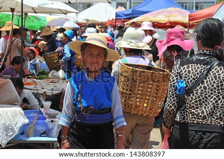 DALI, CHINA - JUNE 15: Chinese farmers sell their goods on the market on June 15, 2013 in Dali, China. Many farmers depend on selling their products here and only make around $800 a year.