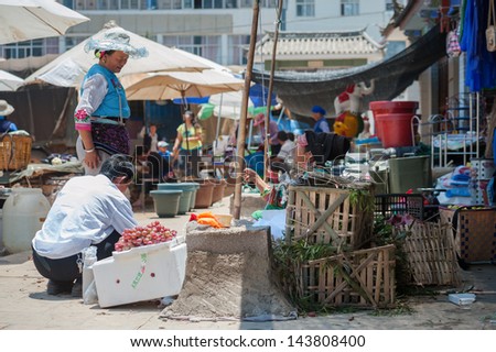 DALI, CHINA - JUNE 15: Chinese farmers sell their goods on the market on June 15, 2013 in Dali, China. Many farmers depend on selling their products here and only make around $800 a year.