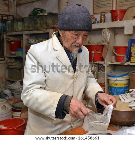 BAISHA, CHINA - MAY 10: World famous herbal doctor Ho preparing traditional herbal medicine in his house on May 10, 2013 in Baisha,China. He is regularly visited by foreign world leaders and celebrities.