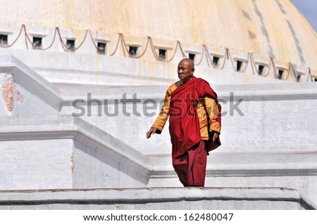 KATHMANDU, NEPAL - MAY 6: Tibetan monk walks the holy Bodhnath circuit during Buddha Jayanti on May 6, 2012 in Kathmandu. Buddha Jayanti is the celebration of the birthday of Buddha.