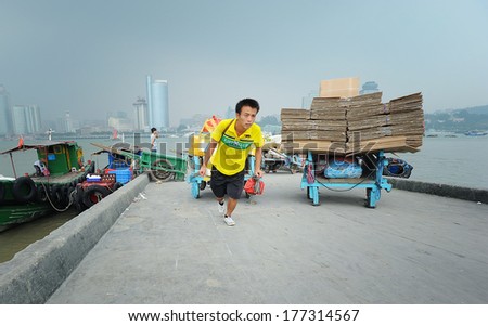 XIAMEN - JULY 7: harbor workers transport goods at Gulangyu harbor on July 7, 2013 in Xiamen, China. Although Xiamen is China's no.8 biggest harbor there is still a lot of physical labor activity.